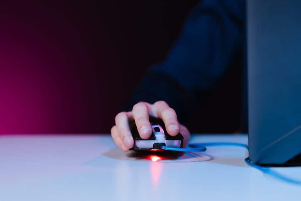 Easy Phishing Simulations Create False Confidence - user with mouse and laptop in a dark room | Virtuas.com